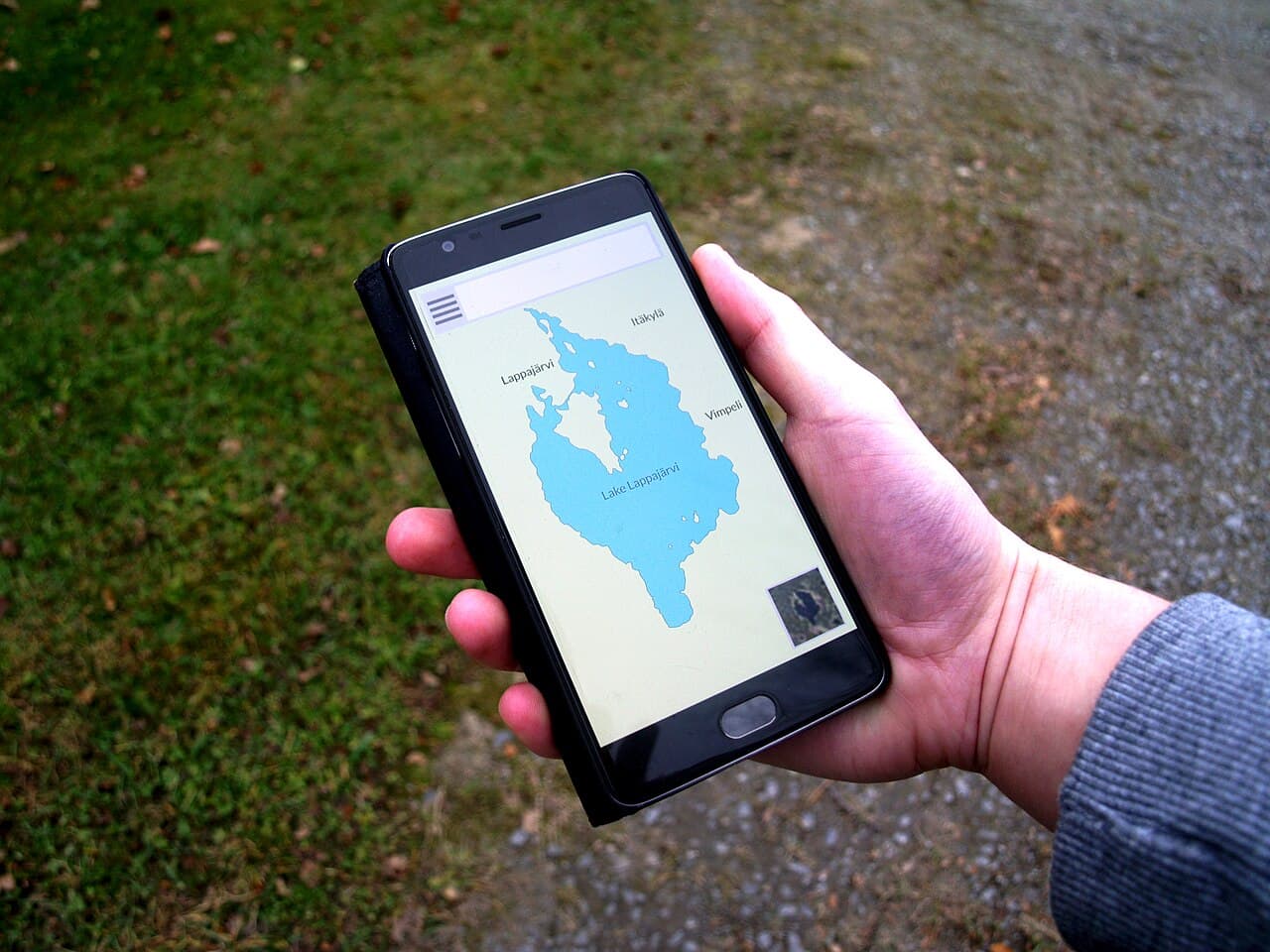 Main tenant un smartphone affichant une carte de localisation
