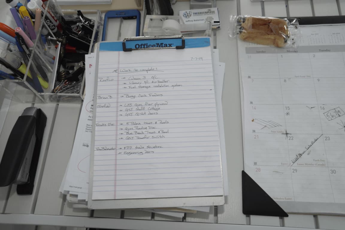 Liste de chantiers à réaliser sur un clipboard à côté d'un calendrier
