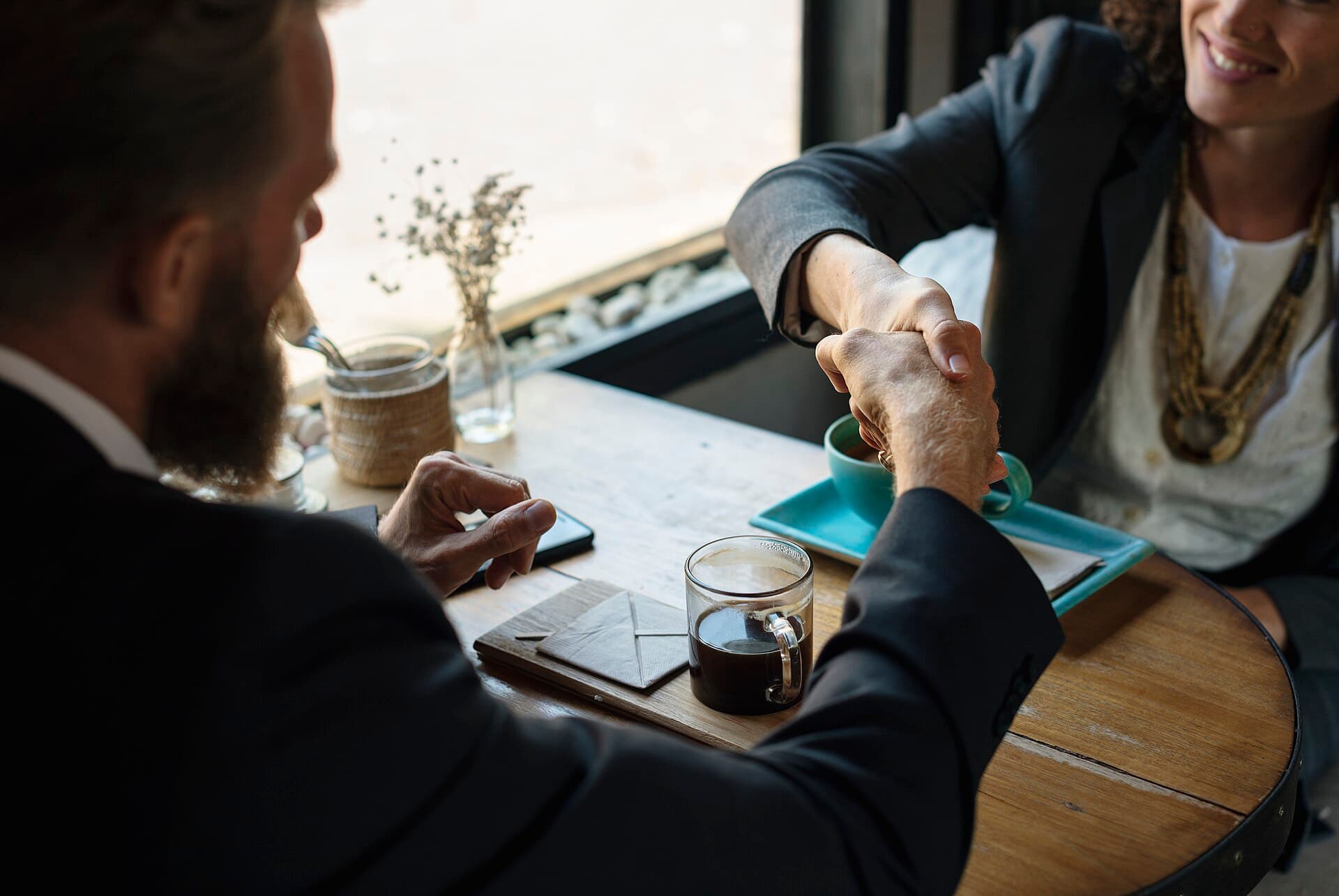 Deux professionnels se serrant la main autour d'une table, concluant un accord
